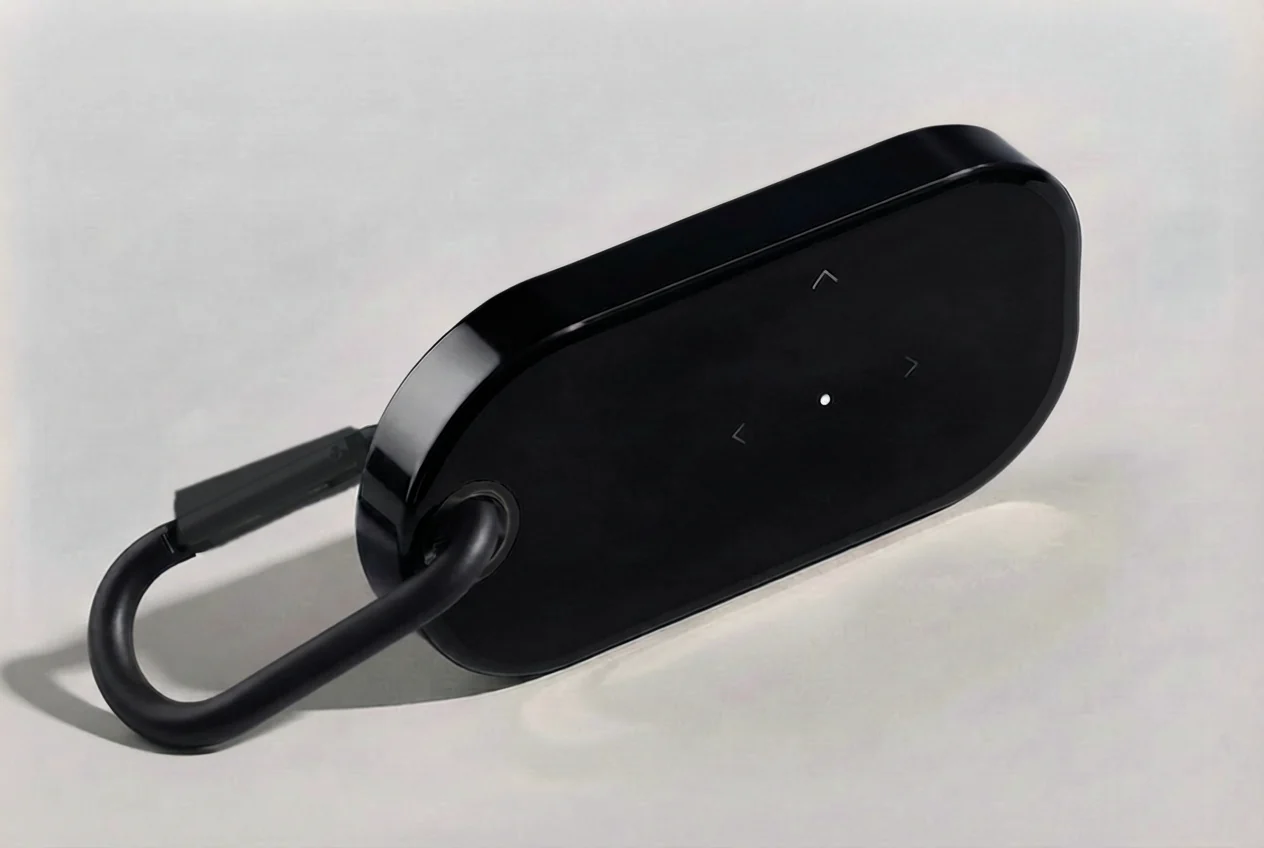 Concept rendering of a dark glass-like clip-on with one black carabiner directly through its reinforced eyelet. A center dot and three quiet movement vectors appear on the face.